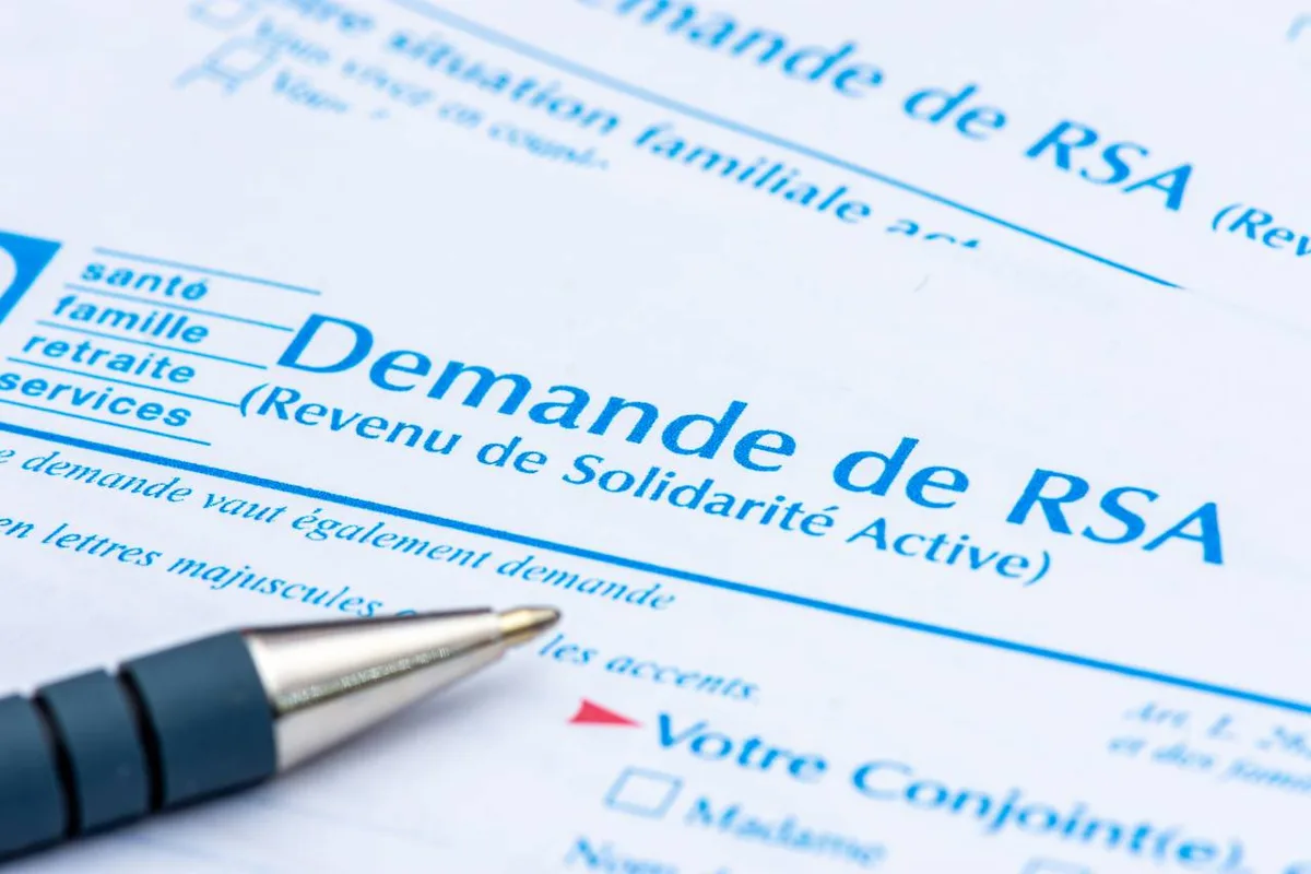 Personne de dos assise dans un atelier de formation avec d'autres participants flous en arrière-plan, lumière naturelle, ambiance bienveillante, pas de texte
